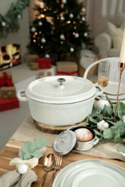 Runde Cocotte 24cm in Weiß auf einem festlich gedeckten Tisch, seitliche Perspektive