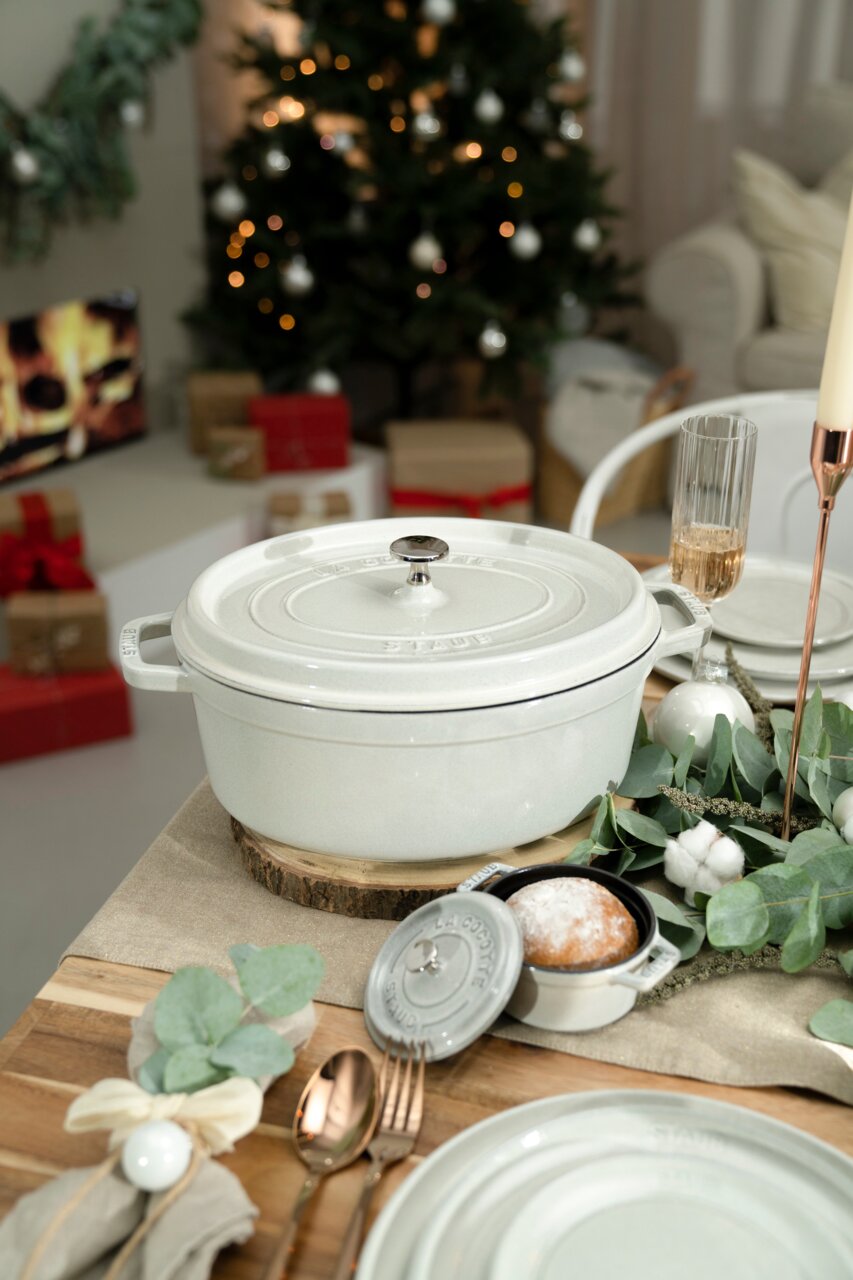 Runde Cocotte 24cm in Weiß auf einem festlich gedeckten Tisch, seitliche Perspektive