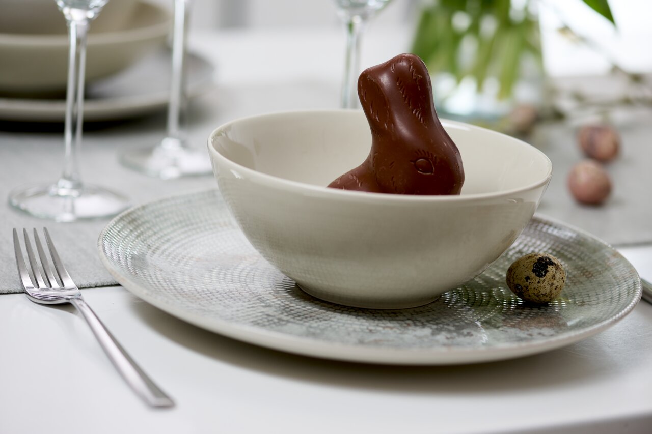 Ritzenhoff & Breker Suppenteller CECINA beige Tiefer Teller mit Perlendesign, darauf eine Schale mit einem Schokoladenhasen, seitliche Perspektive.