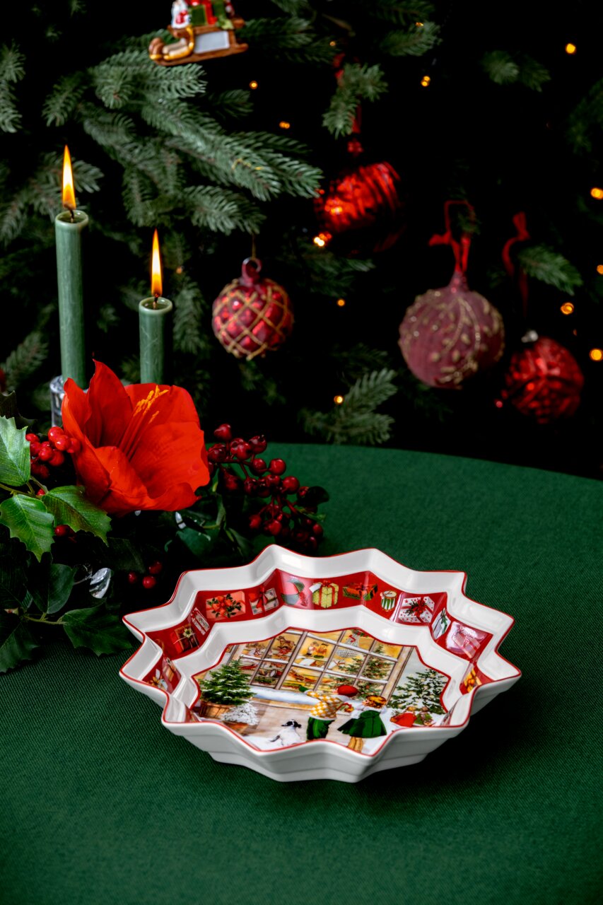 Große, sternförmige Schale mit weihnachtlichem Motiv, umgeben von festlicher Dekoration, aus der Vogelperspektive.