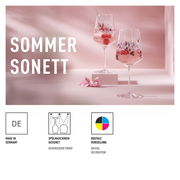 Zwei elegante Sprizzgläser mit floraler Verzierung, gefüllt mit einem sommerlichen Getränk und Beeren, auf einem rosa Hintergrund. Seitliche Perspektive.