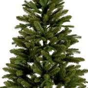 Nahaufnahme eines künstlichen Weihnachtsbaums, Tiaga Tanne, mit dichten grünen Zweigen, perspektivisch von der Seite aufgenommen.