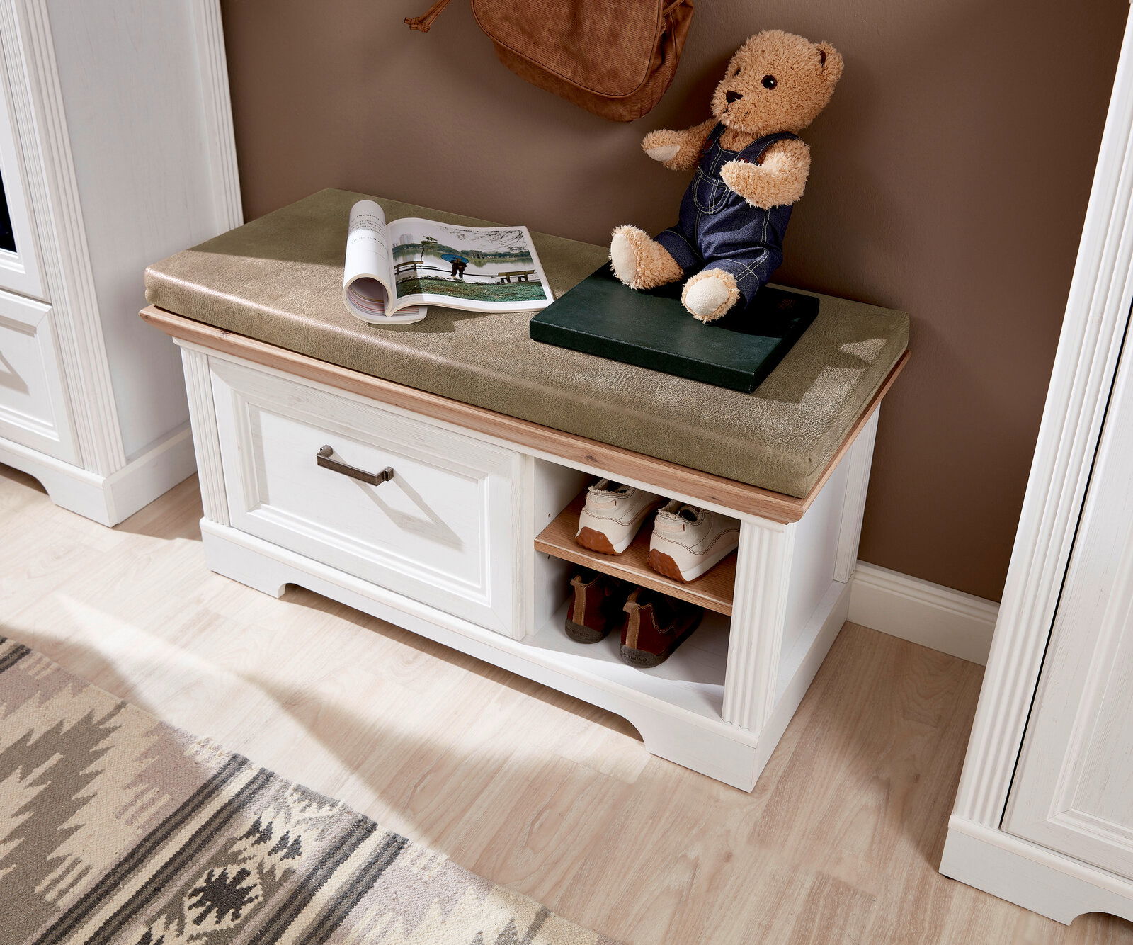 Weiße Bank mit Stauraum, gepolstertem Sitz und Schuhablage, aus der Vogelperspektive fotografiert.