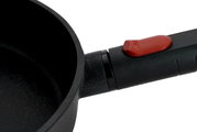 Nahaufnahme einer Gusspfanne Eco Logic 28cm QXR mit schwarzem Griff und rotem Knopf.
