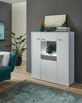 Modernes weißes Highboard mit dekorativer Beleuchtung, frontal fotografiert, umgeben von stilvoller Dekoration und Pflanzen.