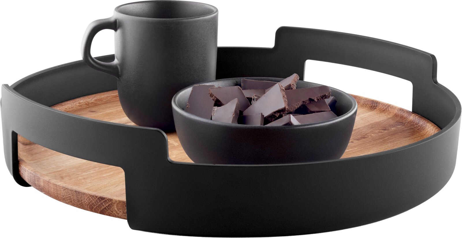 Rundes Serviertablett mit Holzboden und schwarzem Rand mit Griffen, darauf eine schwarze Tasse und eine Schale mit Schokoladenstücken, perspektivisch in schräger Vorderansicht