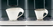 Frontansicht eines Kaffeevollautomaten mit einer weißen Tasse auf der Abtropfschale.