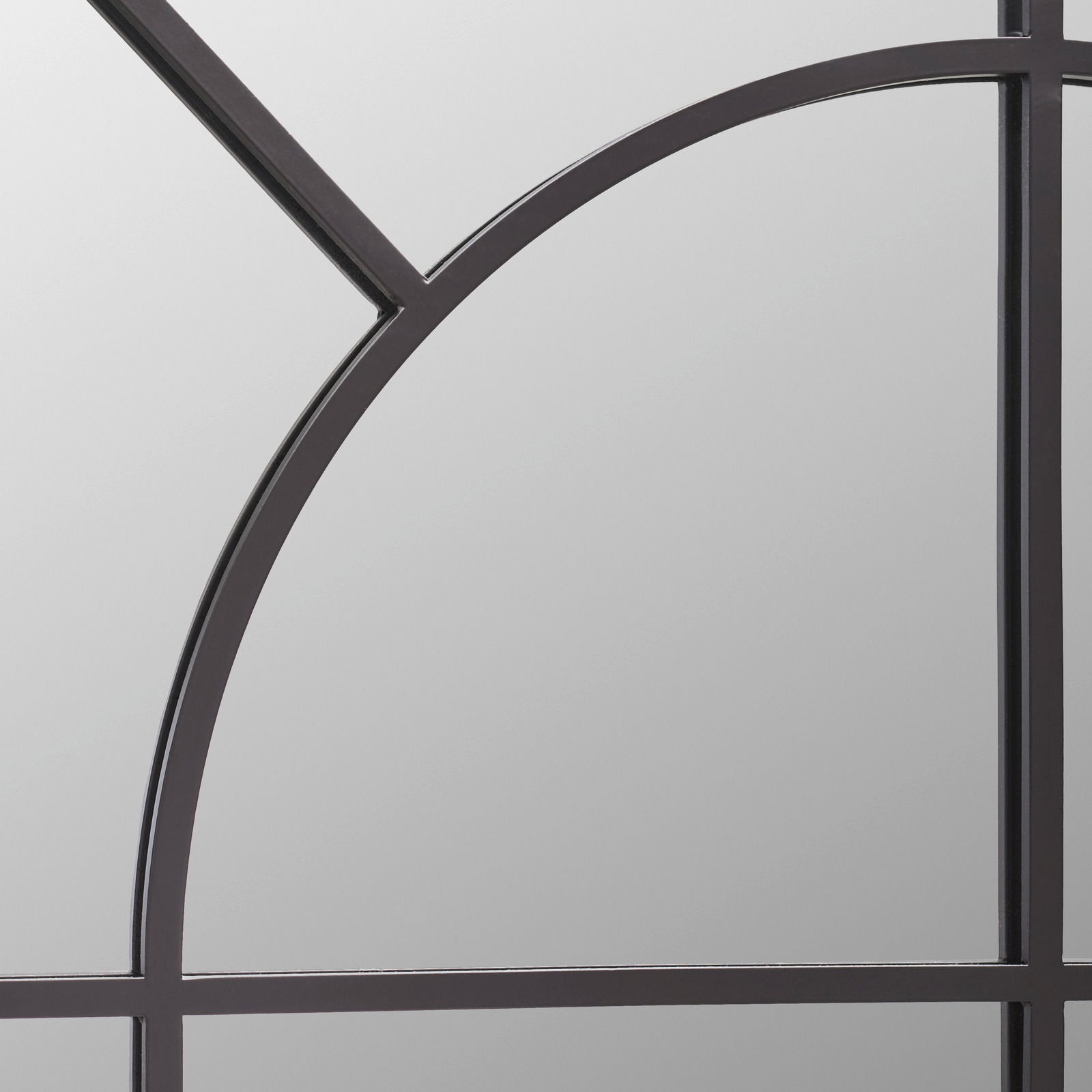 Nahaufnahme eines Spiegels mit schwarzem Metallrahmen und geometrischem Design.