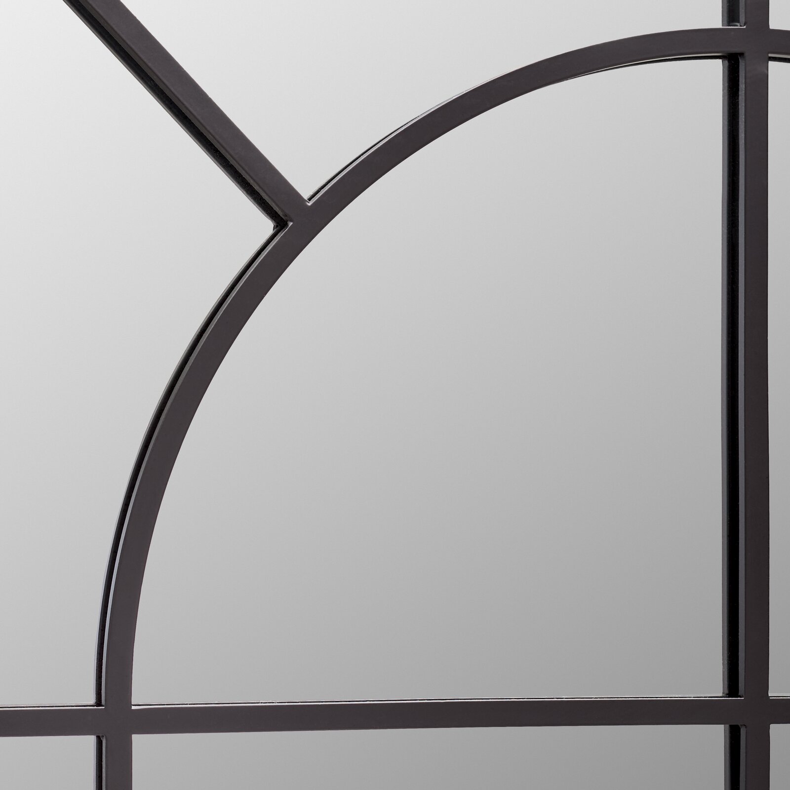 Nahaufnahme eines Spiegels mit schwarzem Metallrahmen und geometrischem Design.