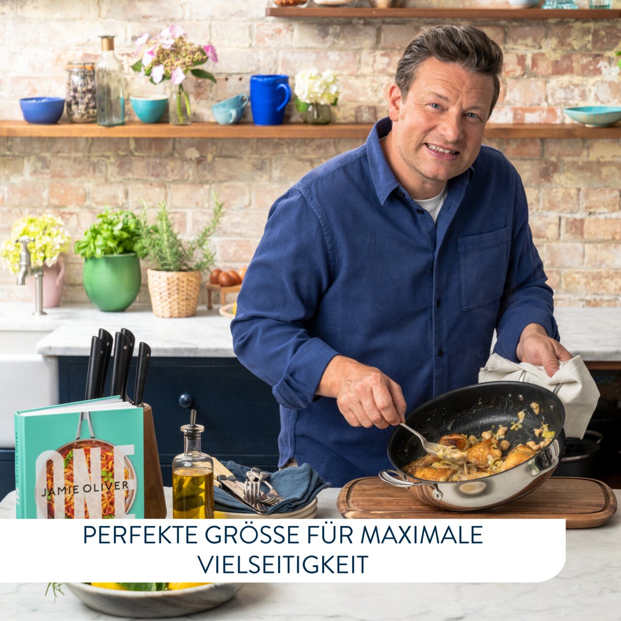 Jamie Oliver in einer Küche, hält eine Servierpfanne mit Essen in der Hand, seitliche Perspektive.
