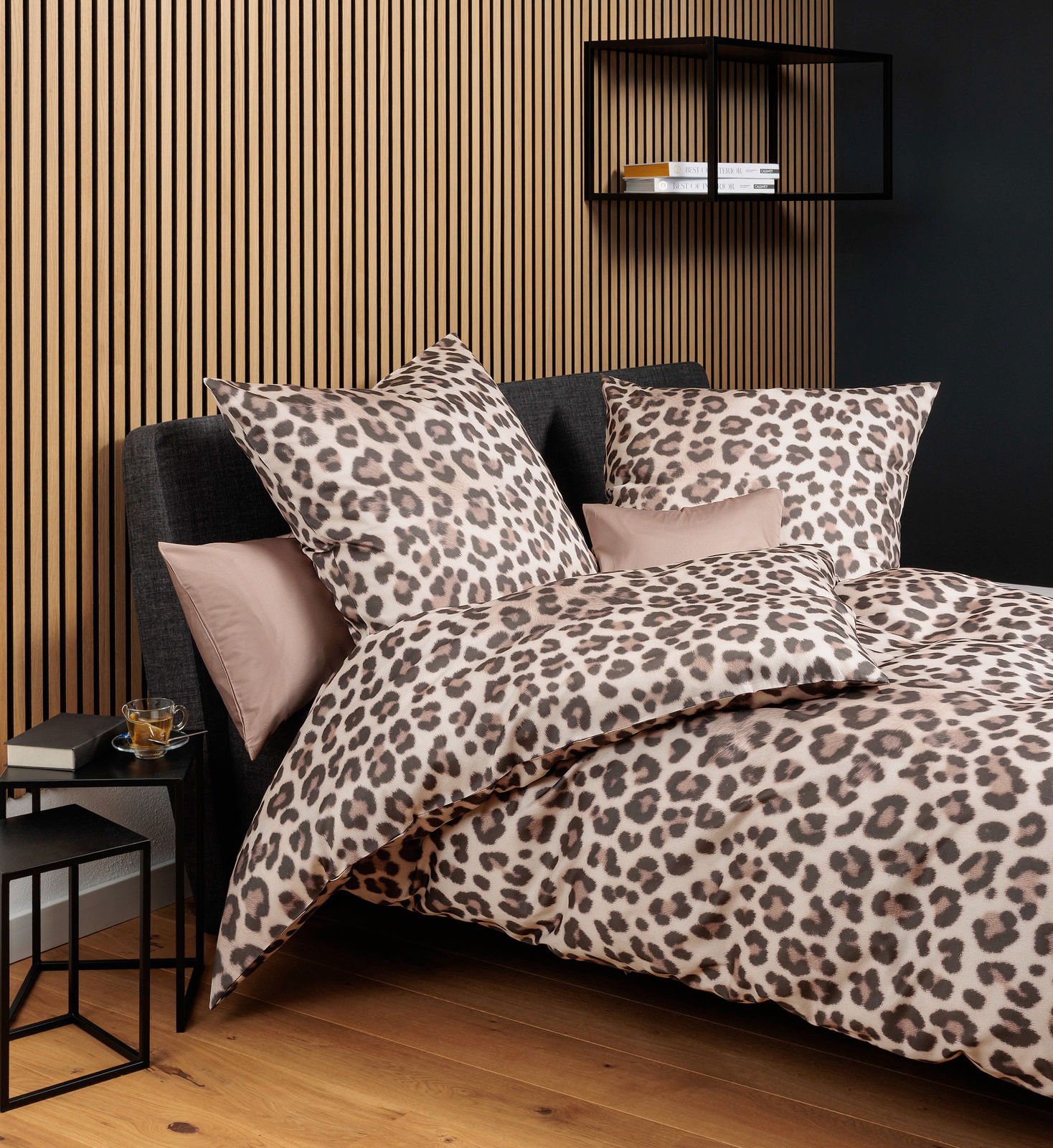 Leopardengemusterte Bettwäsche in einem modernen Schlafzimmer, seitliche Perspektive