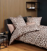 Leopardengemusterte Bettwäsche in einem modernen Schlafzimmer, seitliche Perspektive