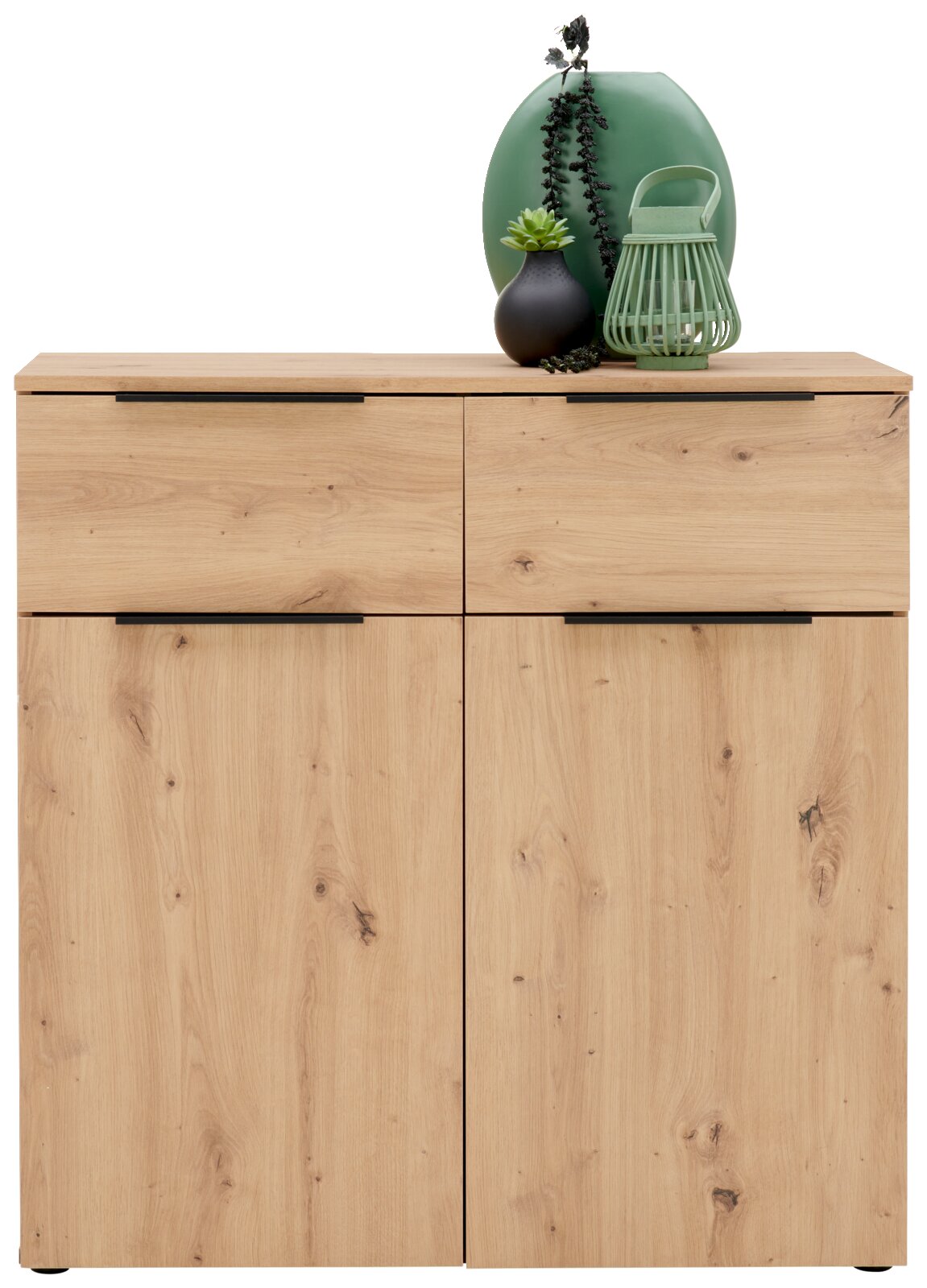 Frontale Ansicht einer modernen Kommode aus hellem Holz mit zwei Schubladen und zwei Türen, dekoriert mit einer grünen Vase, einer schwarzen Vase und einer grünen Laterne.
