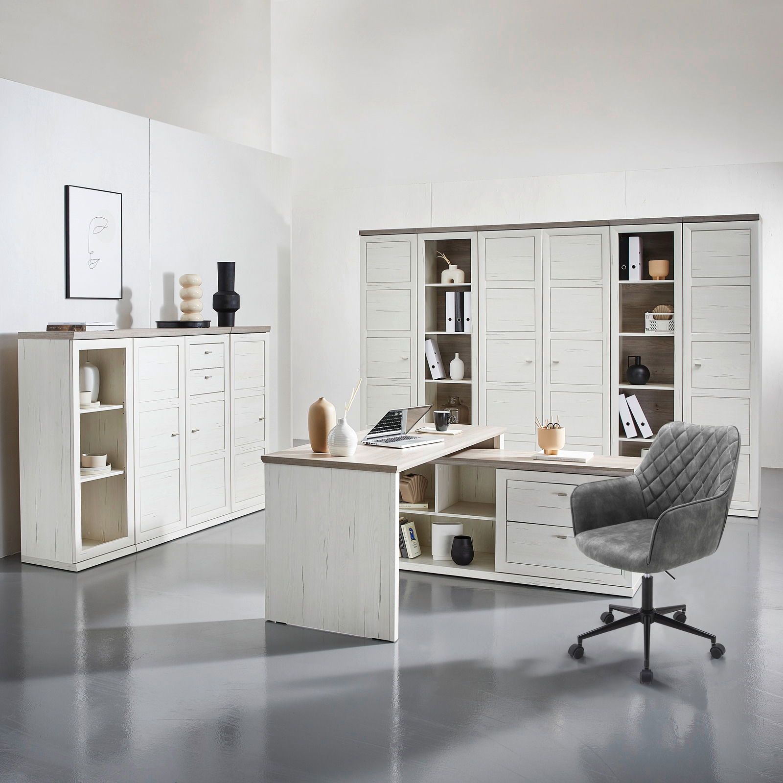 Moderner Eckschreibtisch in heller Holzoptik mit integriertem Stauraum, umgeben von passenden Schränken und einem grauen Bürostuhl, aus der Perspektive eines Betrachters im Raum.