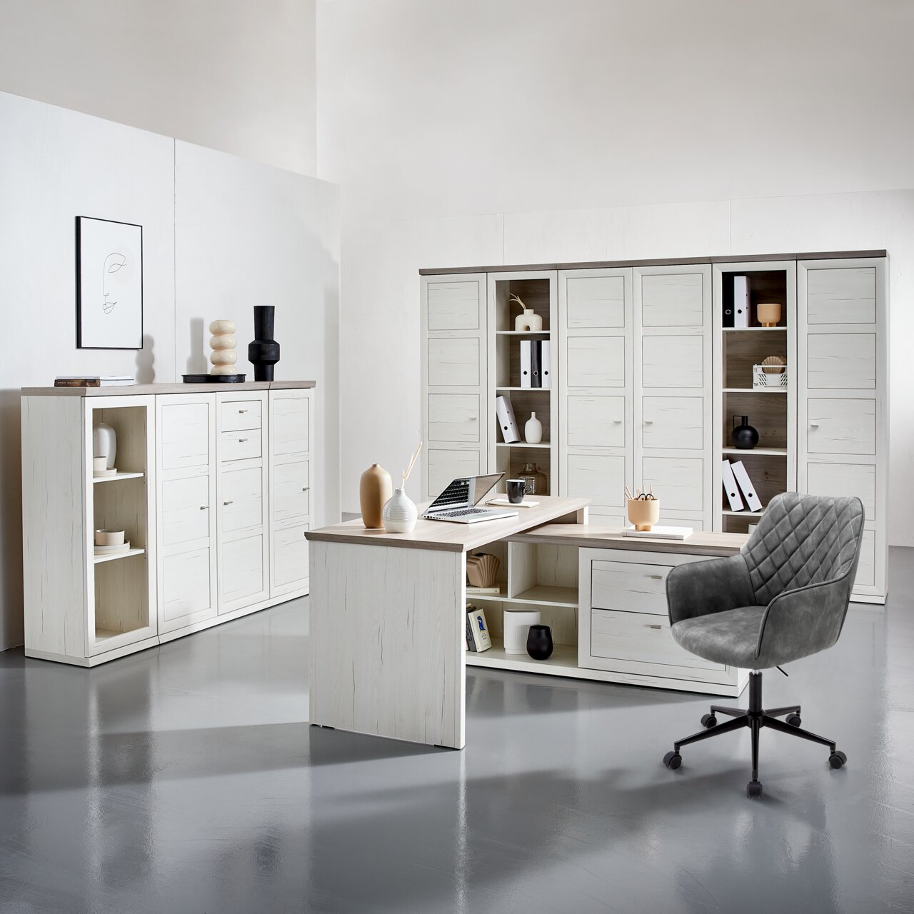 Moderner Eckschreibtisch in heller Holzoptik mit integriertem Stauraum, umgeben von passenden Schränken und einem grauen Bürostuhl, aus der Perspektive eines Betrachters im Raum.