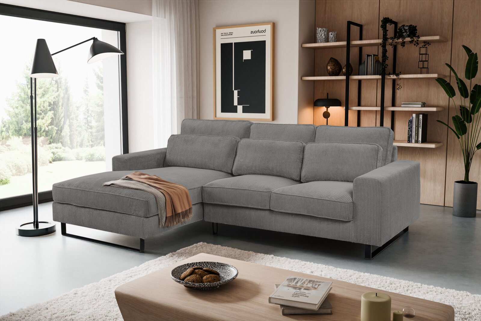 Graues Sofa in L-Form mit linker Ausrichtung, in einem modernen Wohnzimmer mit großen Fenstern und stilvoller Dekoration, aus der Perspektive von vorne links betrachtet.