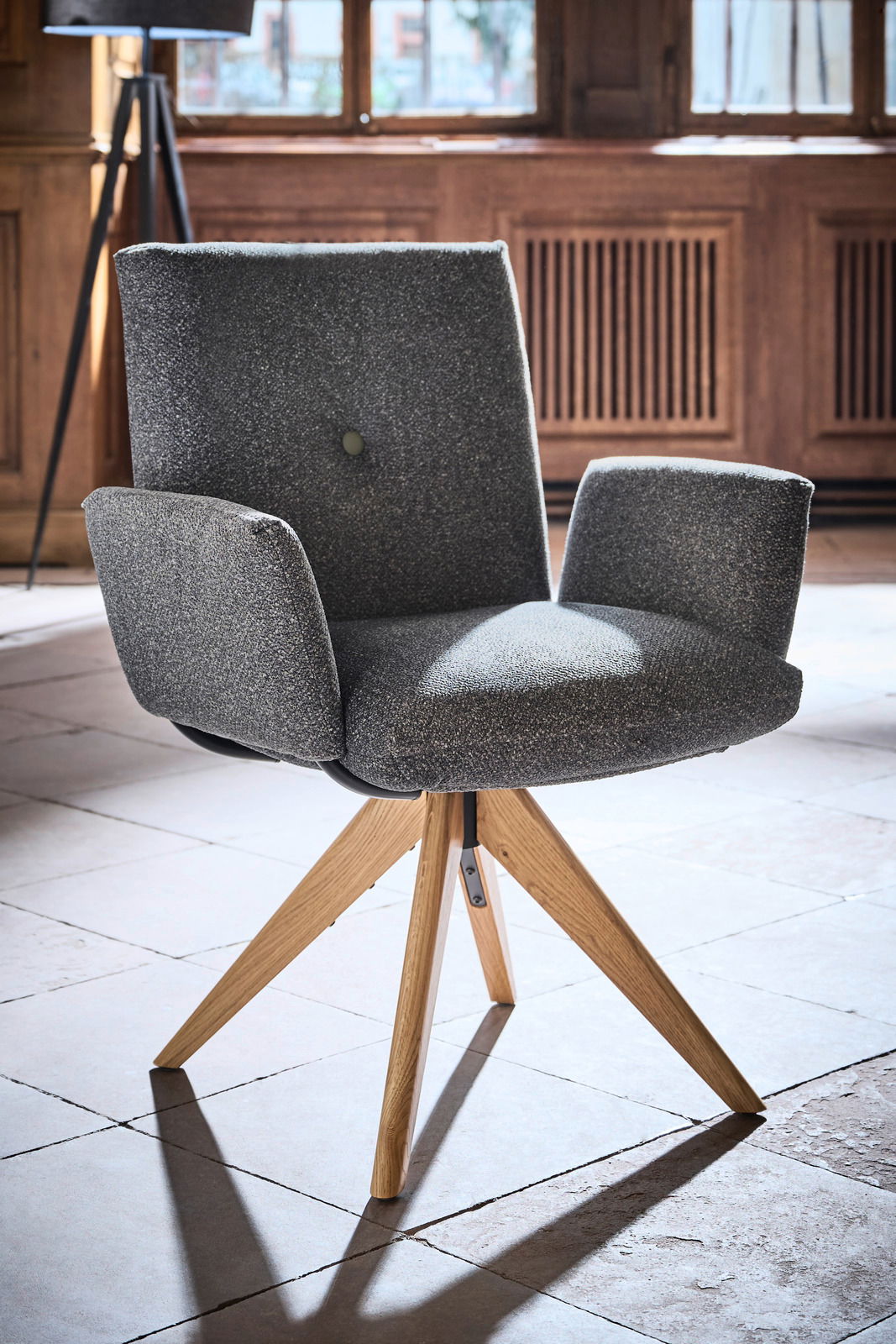 Grauer Armlehnstuhl mit Holzbeinen, seitliche Perspektive