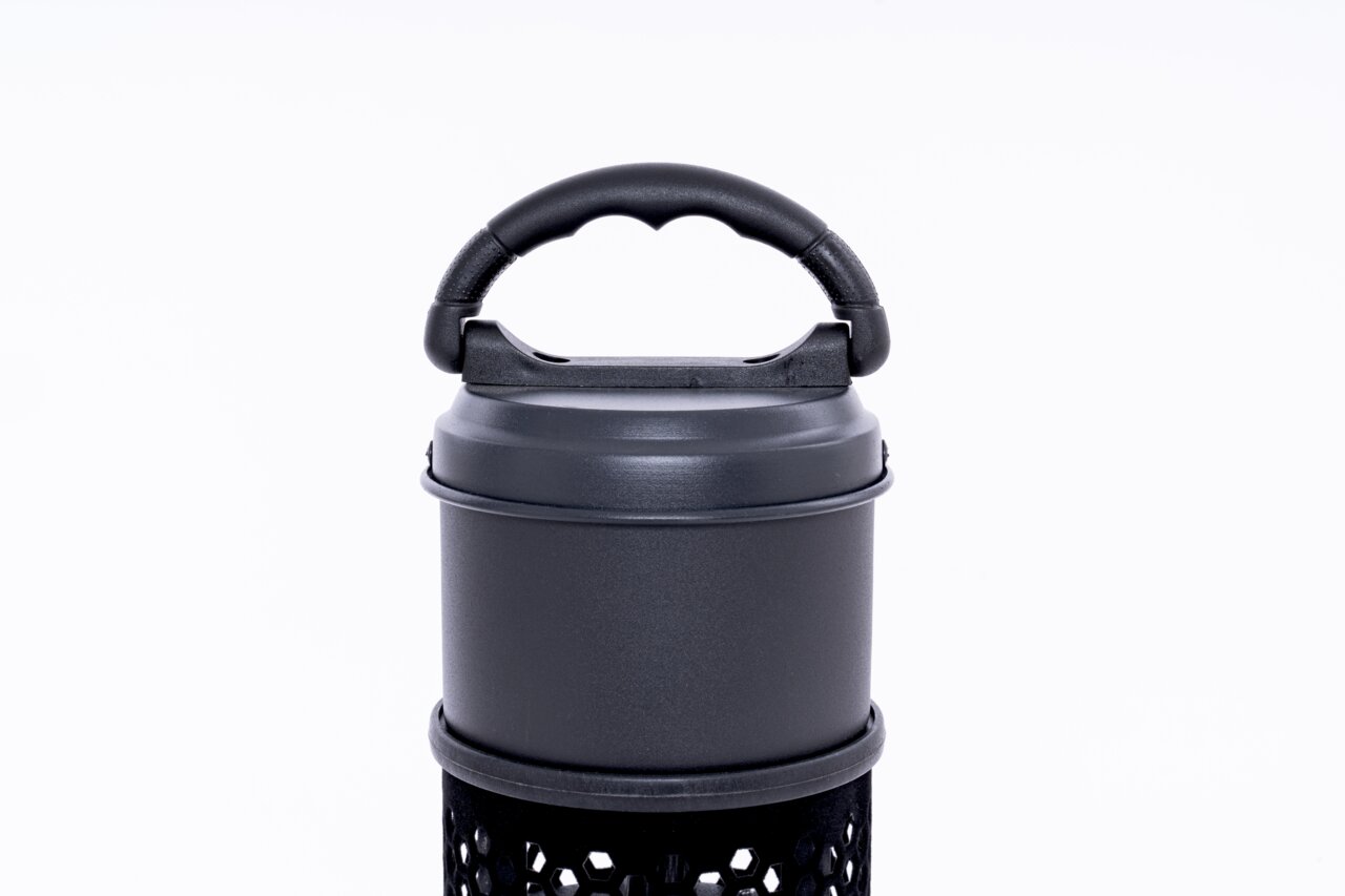 Nahaufnahme eines Infrarot-Standheizstrahlers mit schwarzem Griff und perforiertem Gehäuse, von vorne betrachtet.