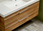 Modern houten badkamermeubel met twee lades en een ingebouwde wastafel, gezien van bovenaf.