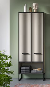 Moderner Hochschrank mit vertikalen Streifen, dekoriert mit Vasen und einer Skulptur auf der Oberseite, frontal fotografiert.