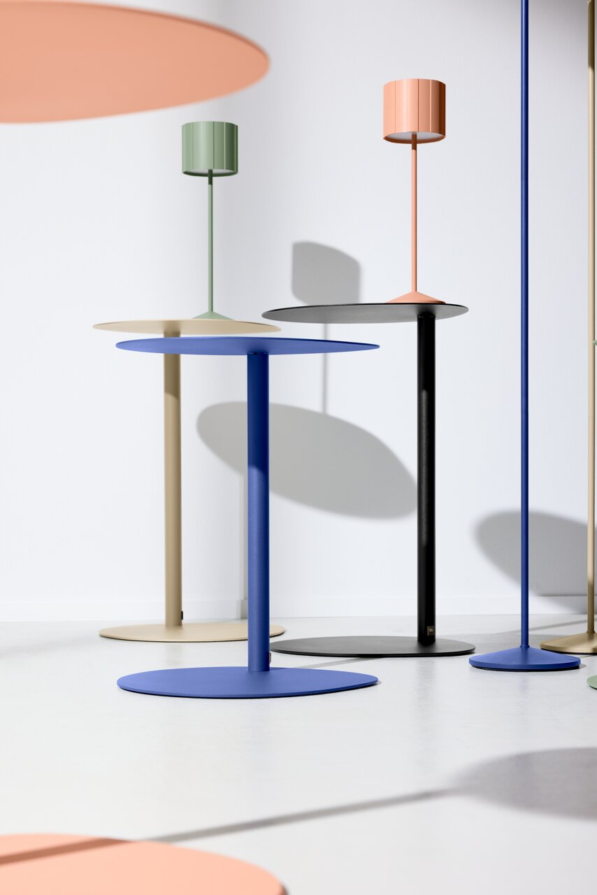 Musterring Beistelltisch ORGANIC Mehrere moderne Beistelltische in verschiedenen Farben wie Blau, Schwarz, Beige und Grün, aus seitlicher Perspektive fotografiert.