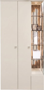 Vooraanzicht van een hoge witte kast met twee greeploze deuren en een verlichte glazen vitrinekast met houten lattenwand en glazen legplanken