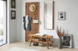 Holzgarderobenpaneel mit Haken, an dem Kleidung und Accessoires hängen, daneben ein Spiegel und eine Bank mit Schuhen, aus seitlicher Perspektive fotografiert.