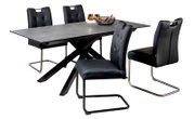 Modernes Esszimmer-Set mit ausziehbarem Tisch in Betonoptik und schwarzem X-Gestell sowie vier schwarzen Polsterstühlen mit Schwinggestell, fotografiert in schräger Vorderansicht vor weißem Hintergrund