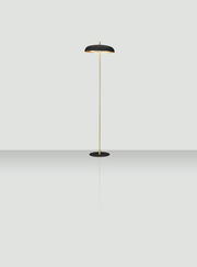 Moderne Stehleuchte mit schwarzem Lampenschirm und goldener Stange, seitliche Perspektive