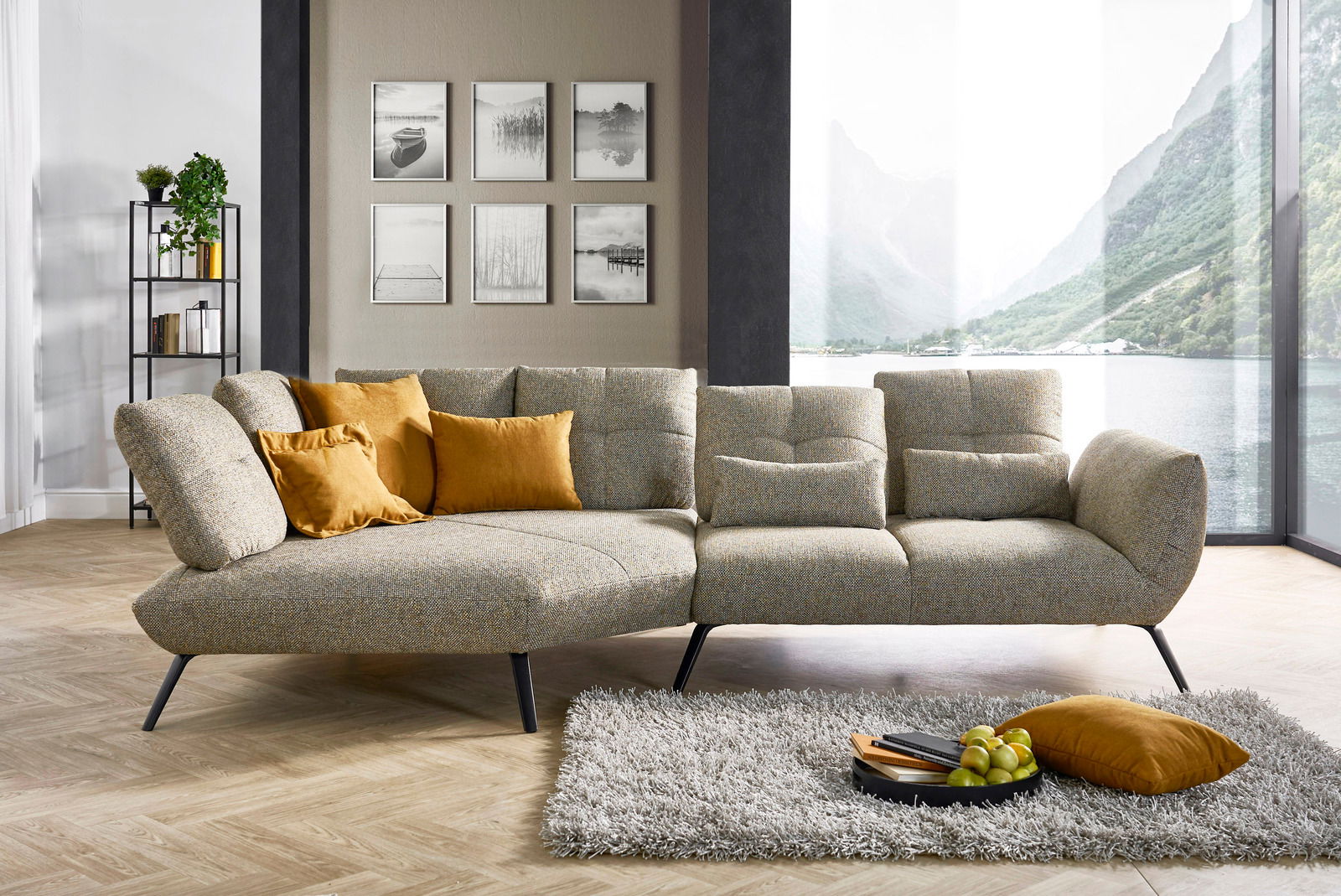 Moderne Rundecke mit grauem Stoffbezug und gelben Kissen, seitliche Perspektive