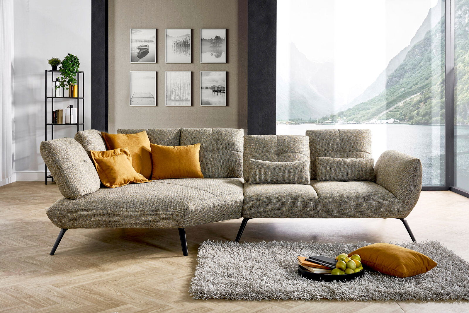 Moderne Rundecke mit grauem Stoffbezug und gelben Kissen, seitliche Perspektive