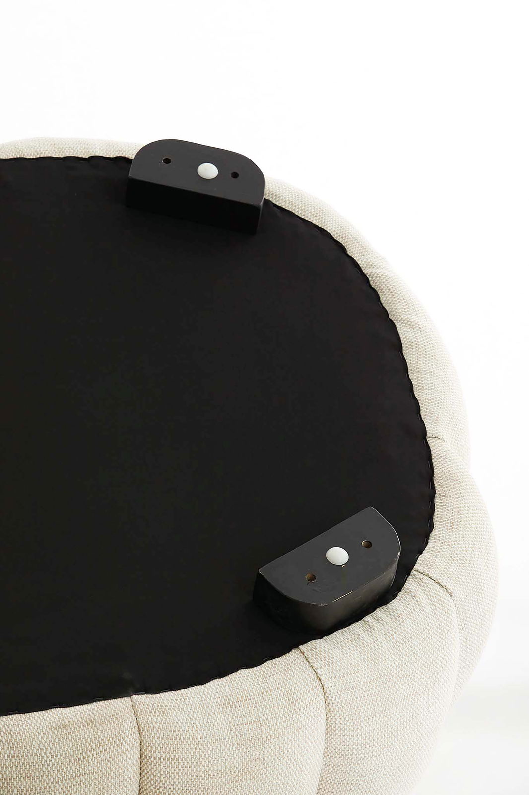 Unterseite eines runden, gepolsterten Möbelstücks mit schwarzem Stoffbezug und Befestigungselementen, Perspektive von unten.