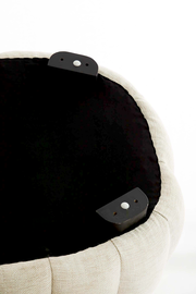 Unterseite eines runden, gepolsterten Möbelstücks mit schwarzem Stoffbezug und Befestigungselementen, Perspektive von unten.