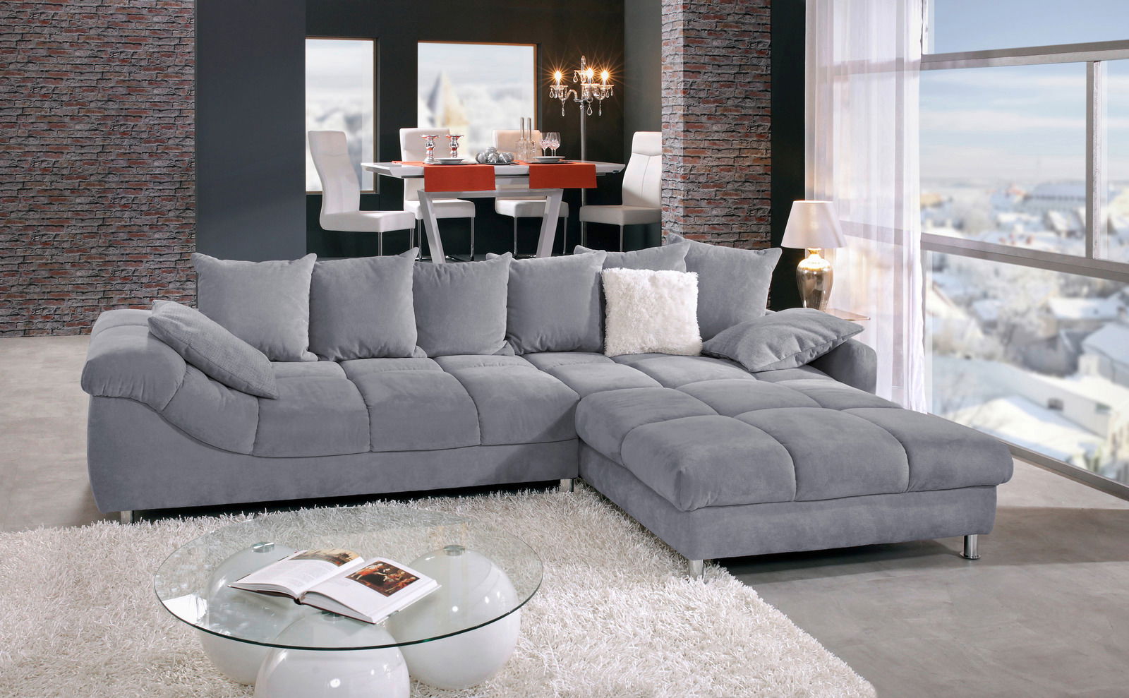 Graues Ecksofa in einem modernen Wohnzimmer mit Blick auf den Esstisch im Hintergrund, seitliche Perspektive.