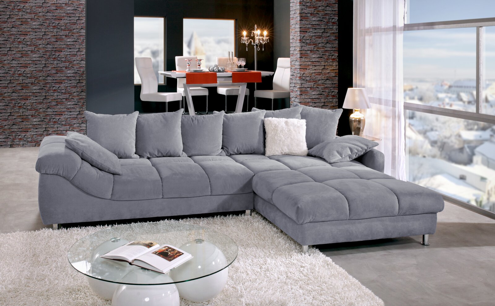 Z2 Ecksofa BROOKLYN II Graues Ecksofa in einem modernen Wohnzimmer mit Blick auf den Esstisch im Hintergrund, seitliche Perspektive.