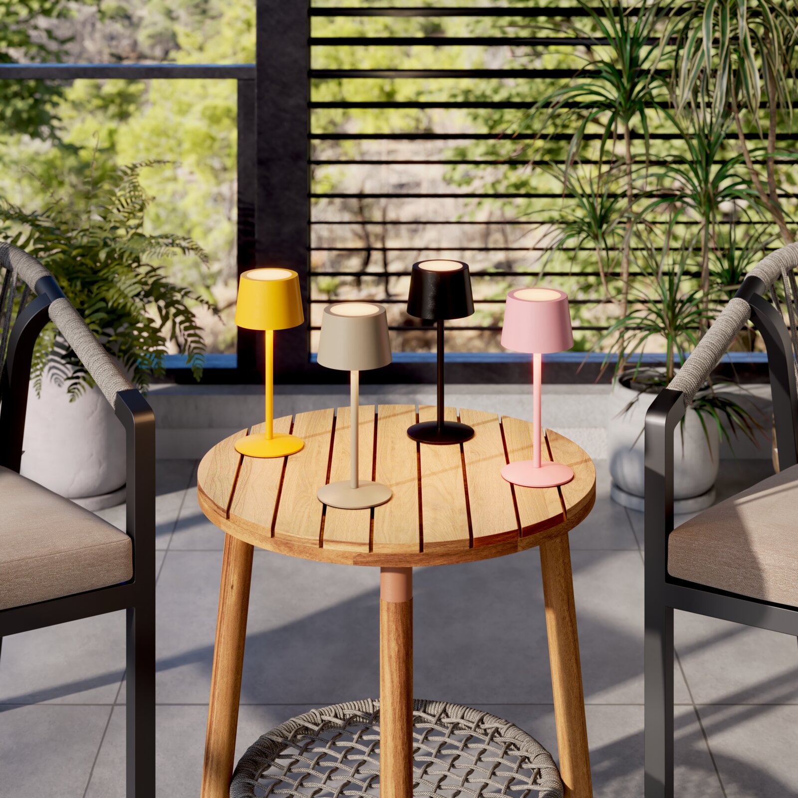 Vier moderne draadloze led-tafellampen in geel, beige, zwart en roze op een ronde houten tafel op het balkon, van voren gefotografeerd vanuit een iets hoger standpunt