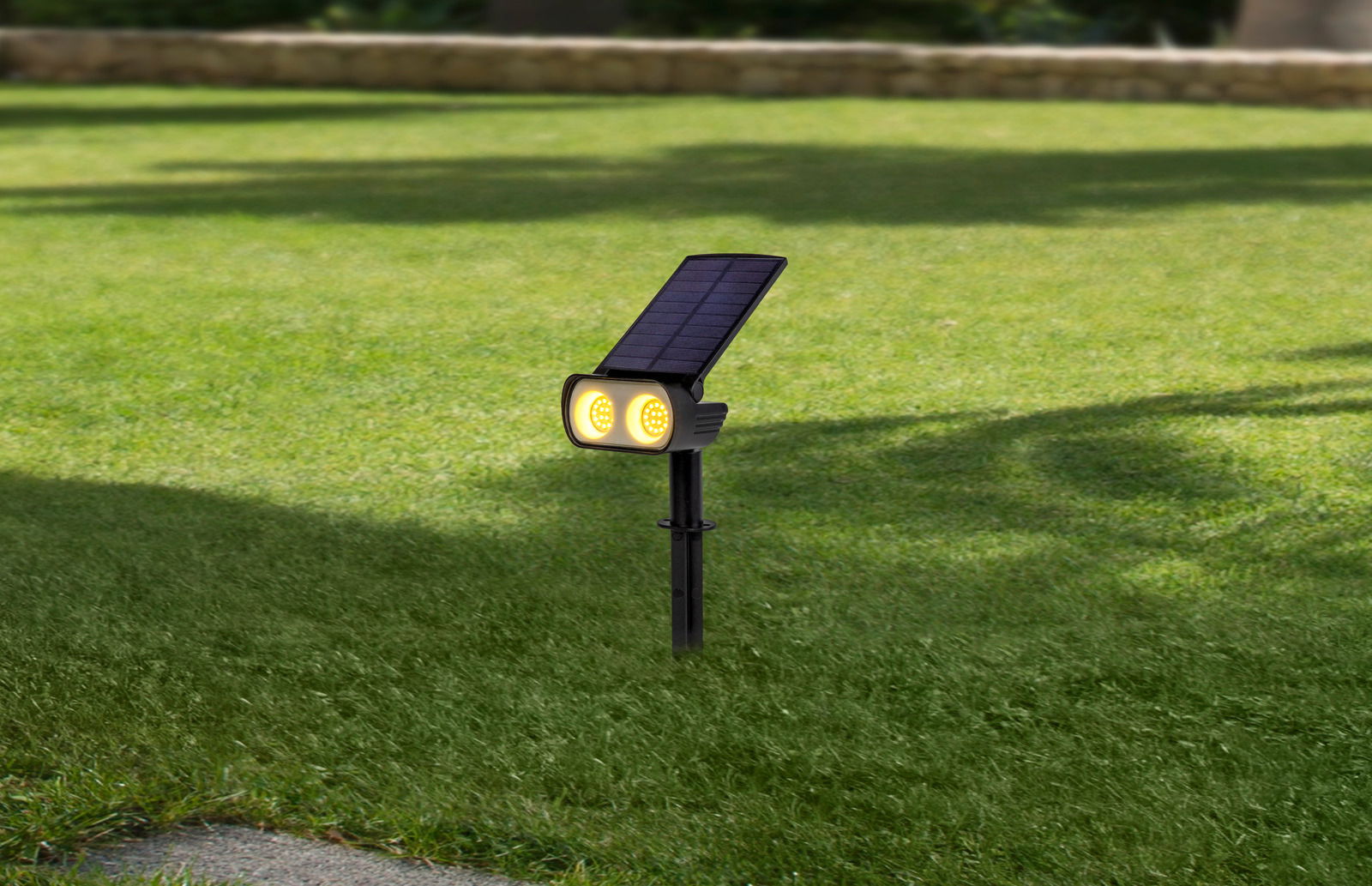 Solarleuchte mit zwei gelben LED-Lichtern und Solarpanel, auf Rasenfläche montiert, seitliche Perspektive