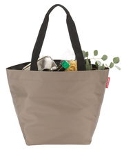 Olivefarbene Einkaufstasche mit schwarzen Henkeln, gefüllt mit Lebensmitteln, aus der Vorderansicht.