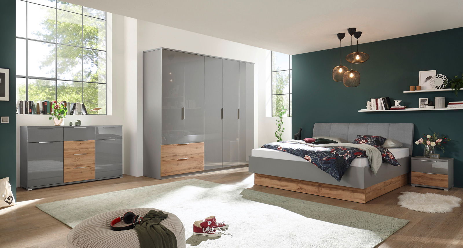 Moderne Kommode in einem stilvollen Schlafzimmer, mit grauen Hochglanzfronten und Holzelementen, aus der Perspektive von vorne links.