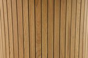 Nahaufnahme von vertikalen Holzlatten mit natürlicher Maserung, aus der Perspektive von oben betrachtet.