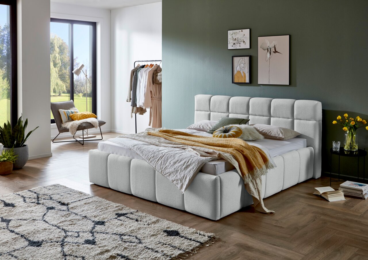 Modernes Polsterbett in einem stilvollen Schlafzimmer, seitliche Perspektive