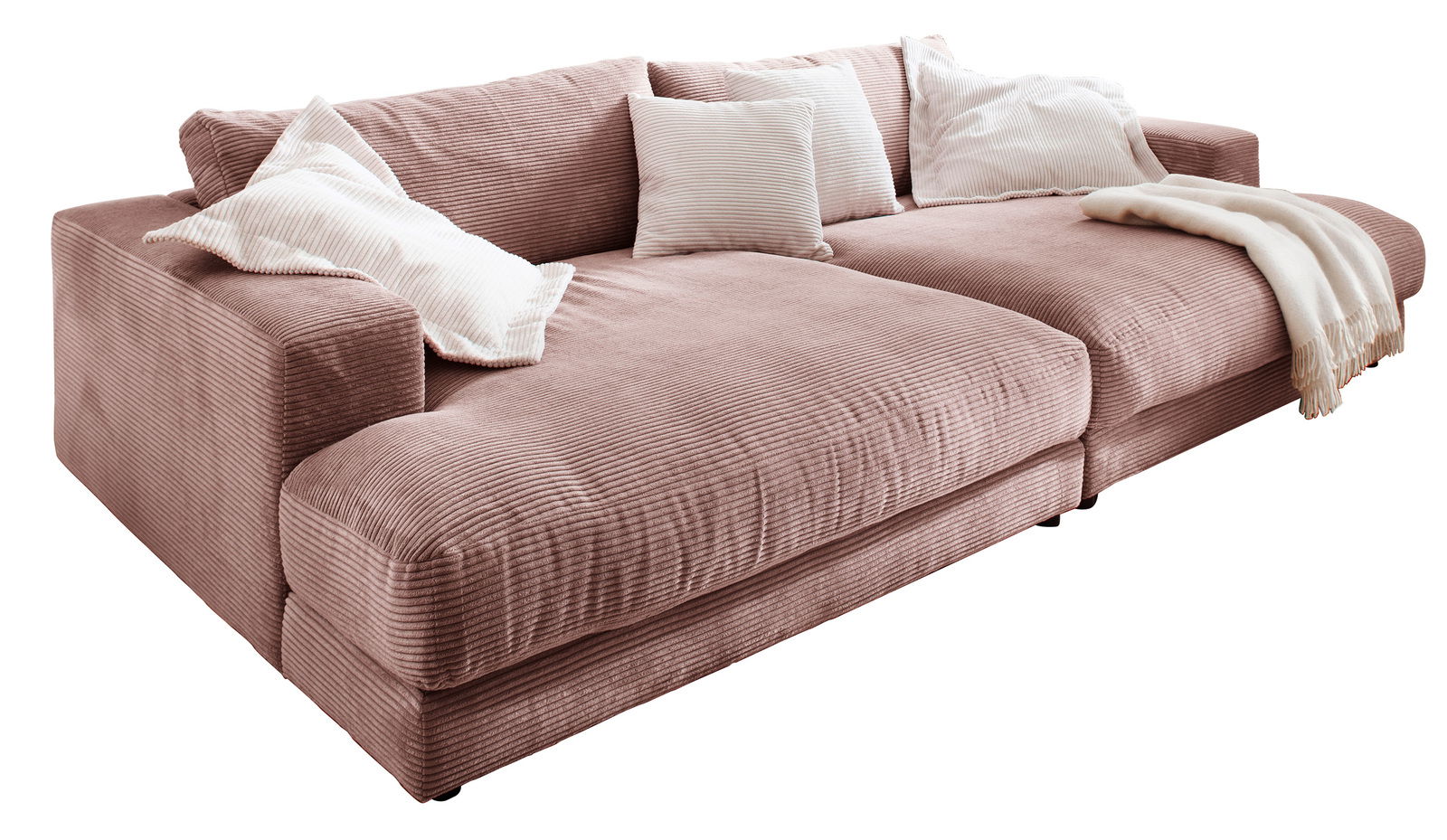 Großes, gemütliches Megasofa in rosa Cordstoff mit mehreren weißen Kissen und einer Decke, seitliche Perspektive