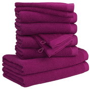 Ein Stapel aus zehn lila Handtüchern in verschiedenen Größen, von der Seite betrachtet.