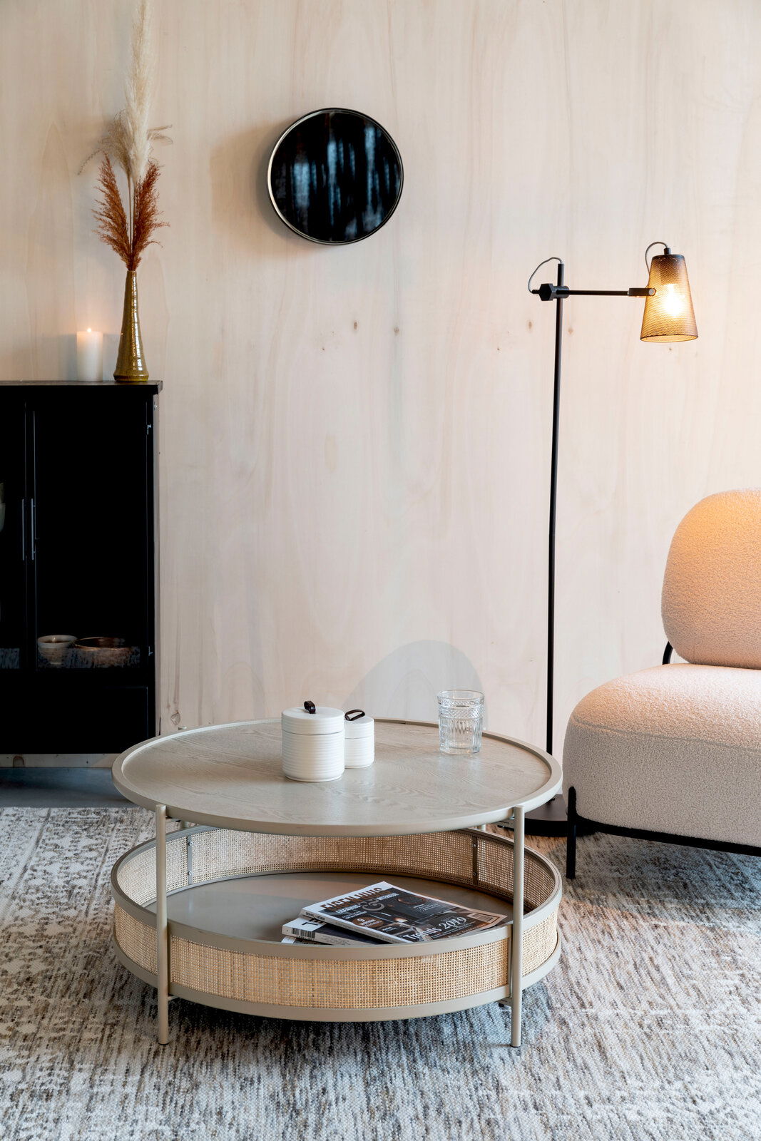 Z2 Couchtisch MAKATO Runder Couchtisch mit zwei Ebenen, aus hellem Holz und Rattan, in einem modernen Wohnzimmer mit seitlicher Perspektive.