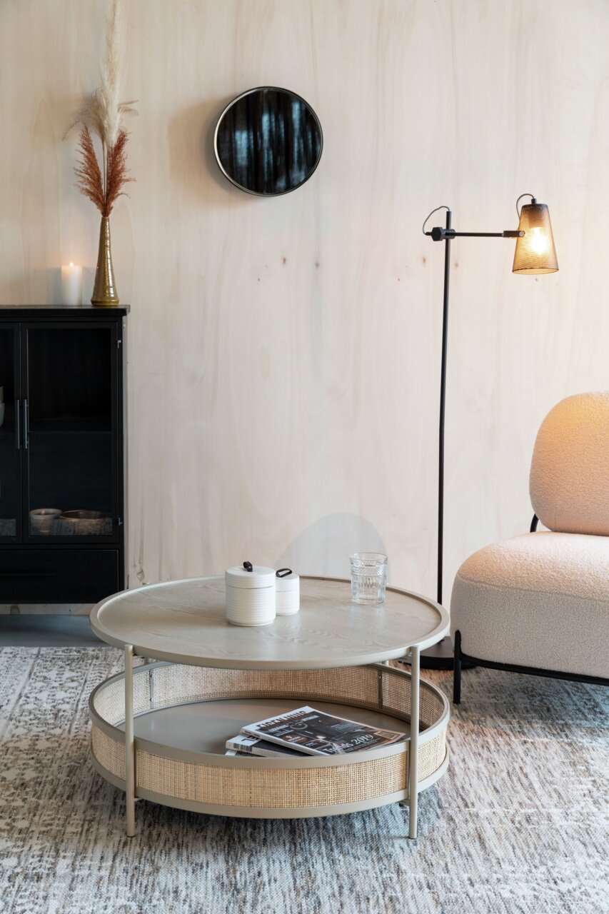 Runder Couchtisch mit zwei Ebenen, aus hellem Holz und Rattan, in einem modernen Wohnzimmer mit seitlicher Perspektive.