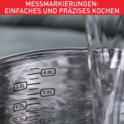 Nahaufnahme eines Topfes mit Messmarkierungen von 2,5L bis 4,0L, Wasser wird hineingegossen.