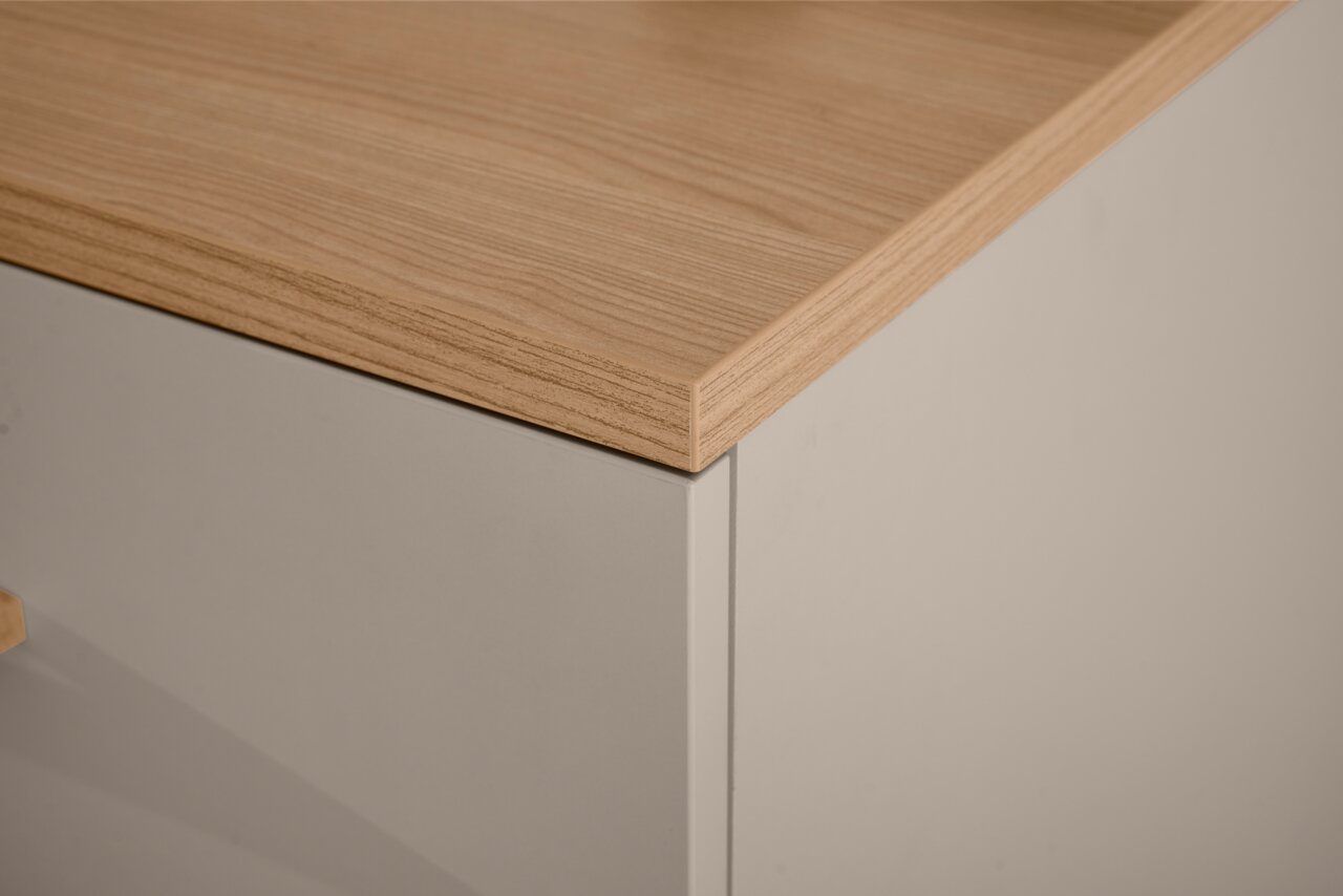 Nahaufnahme einer Ecke eines Standregals mit Holzoberfläche und weißem Korpus, Perspektive von oben.