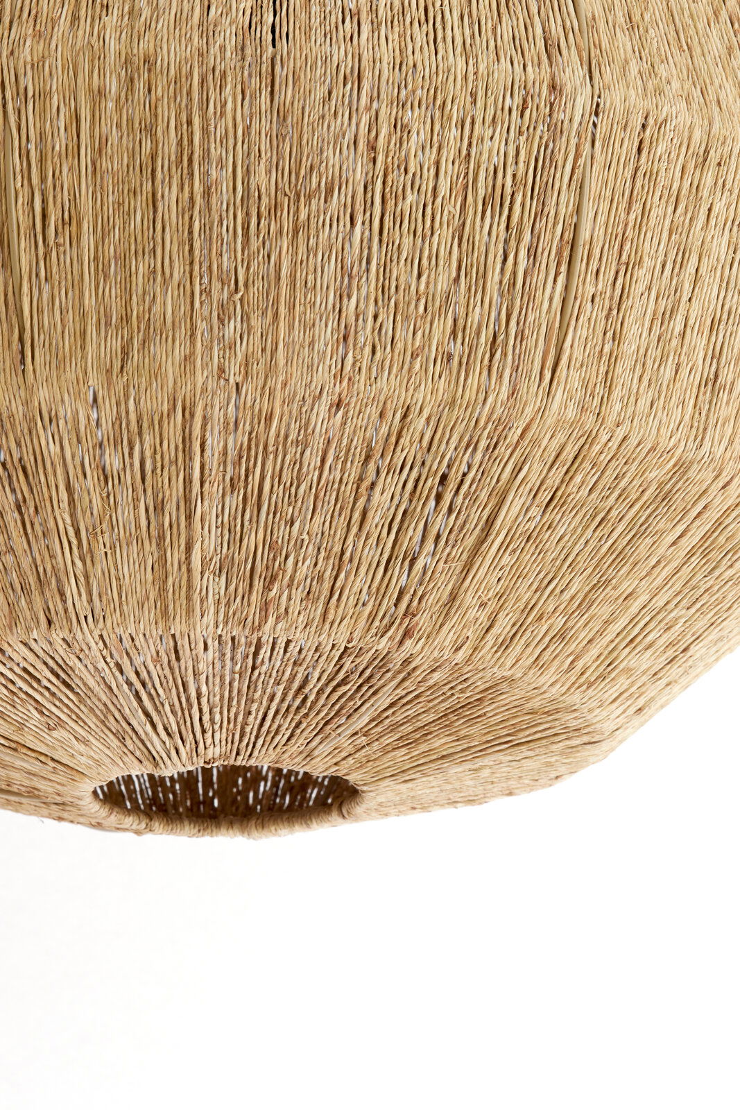 Nahaufnahme einer Hängeleuchte aus geflochtenem Naturmaterial, von unten betrachtet.