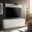 Modernes weißes TV-Lowboard mit Wandboard, frontal betrachtet, in einem stilvoll eingerichteten Wohnzimmer mit großem Fernseher und Dekoration.