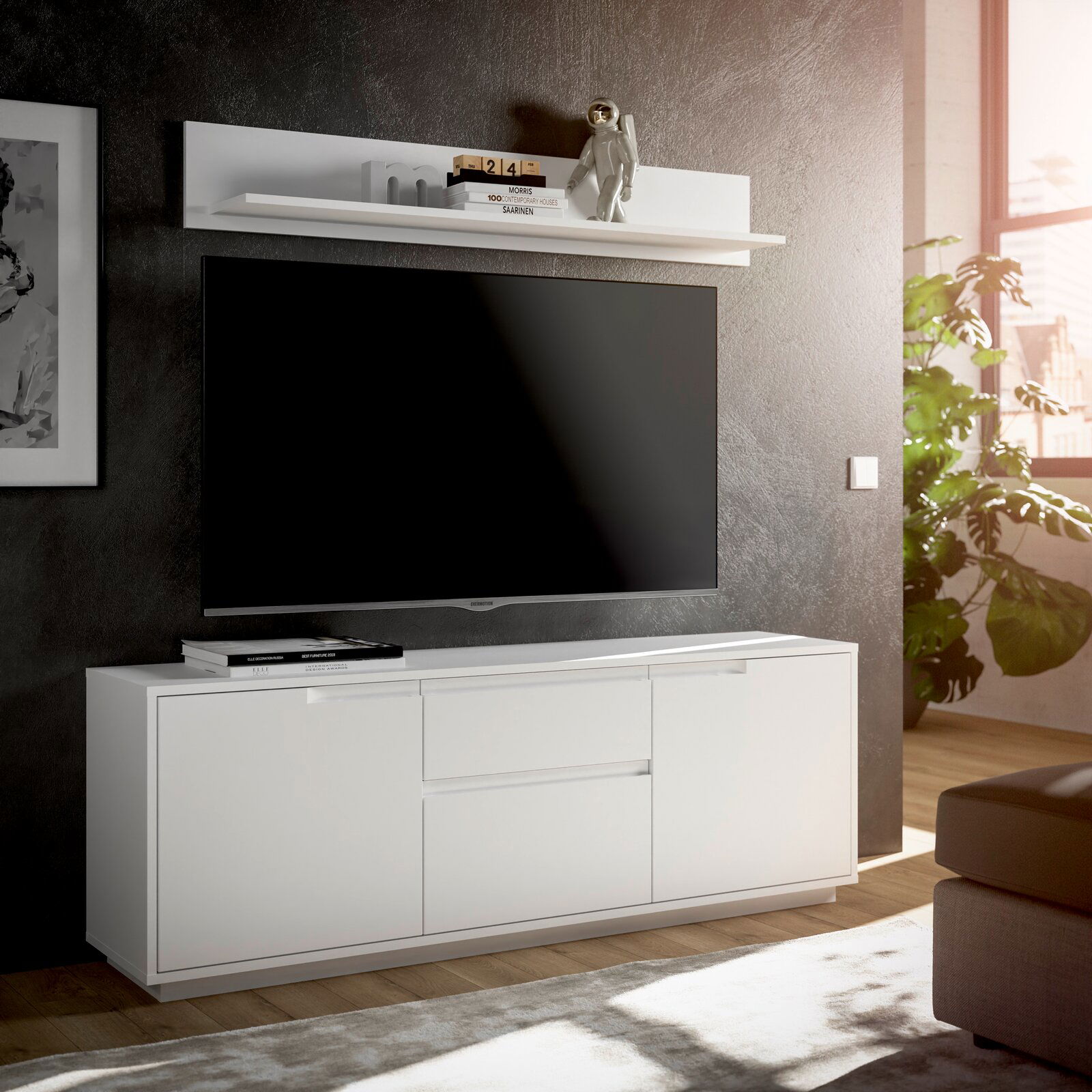 Modernes weißes TV-Lowboard mit Wandboard, frontal betrachtet, in einem stilvoll eingerichteten Wohnzimmer mit großem Fernseher und Dekoration.